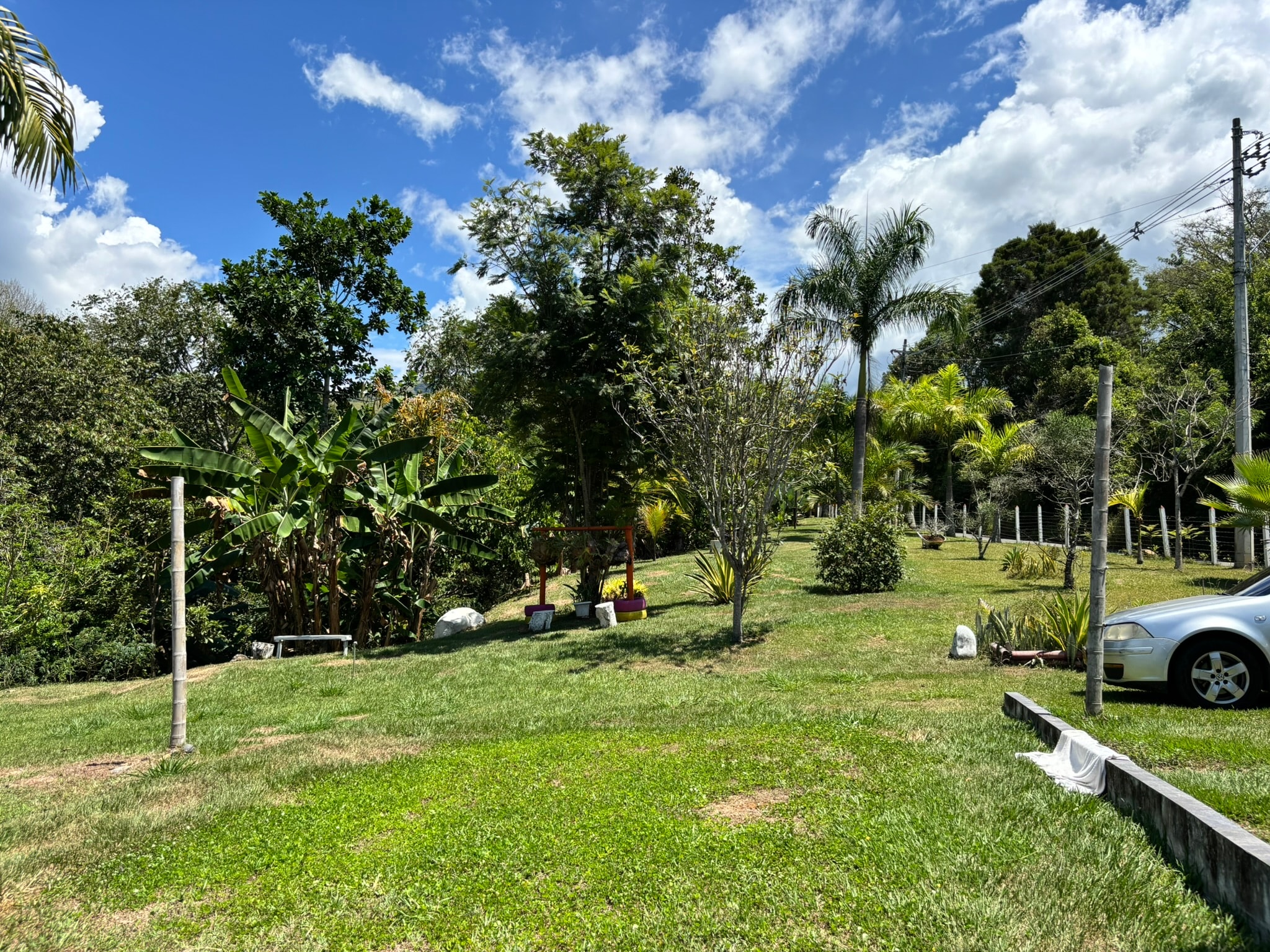 Amplia zona verde y parqueadero de Quitamarán, rodeados de vegetación y árboles
